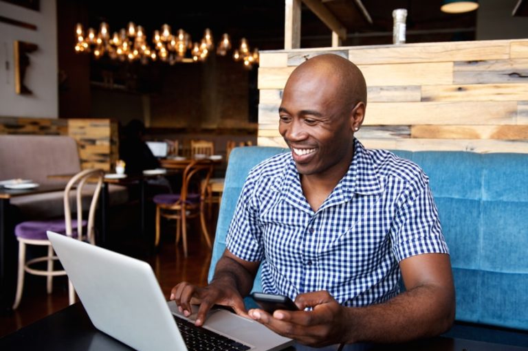 Man in cafe looking at laptop