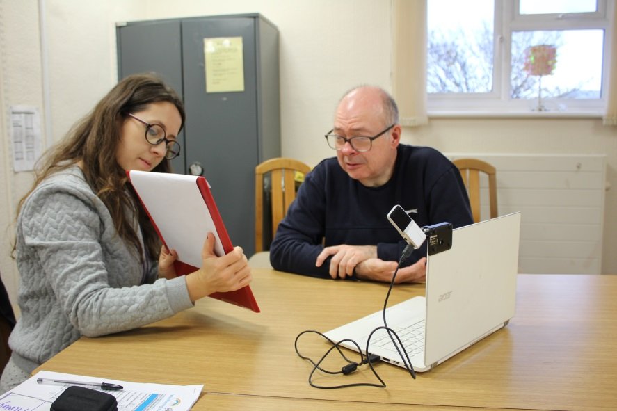 Lady showing Innovate Trust client how to use technology