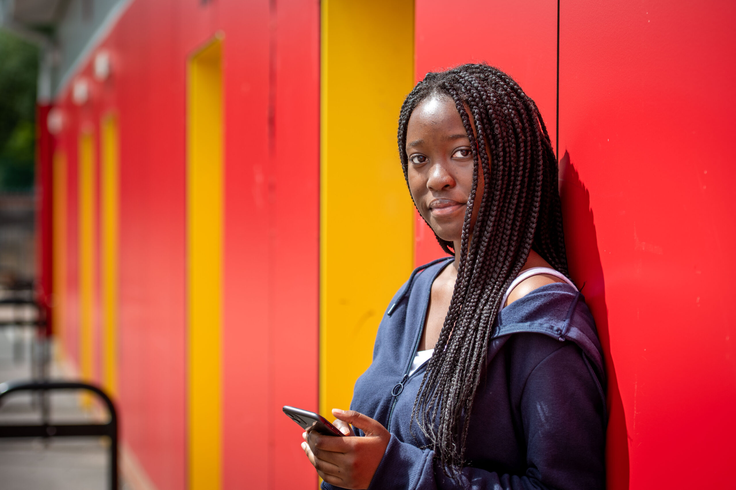 Young college student holding her mobile phone