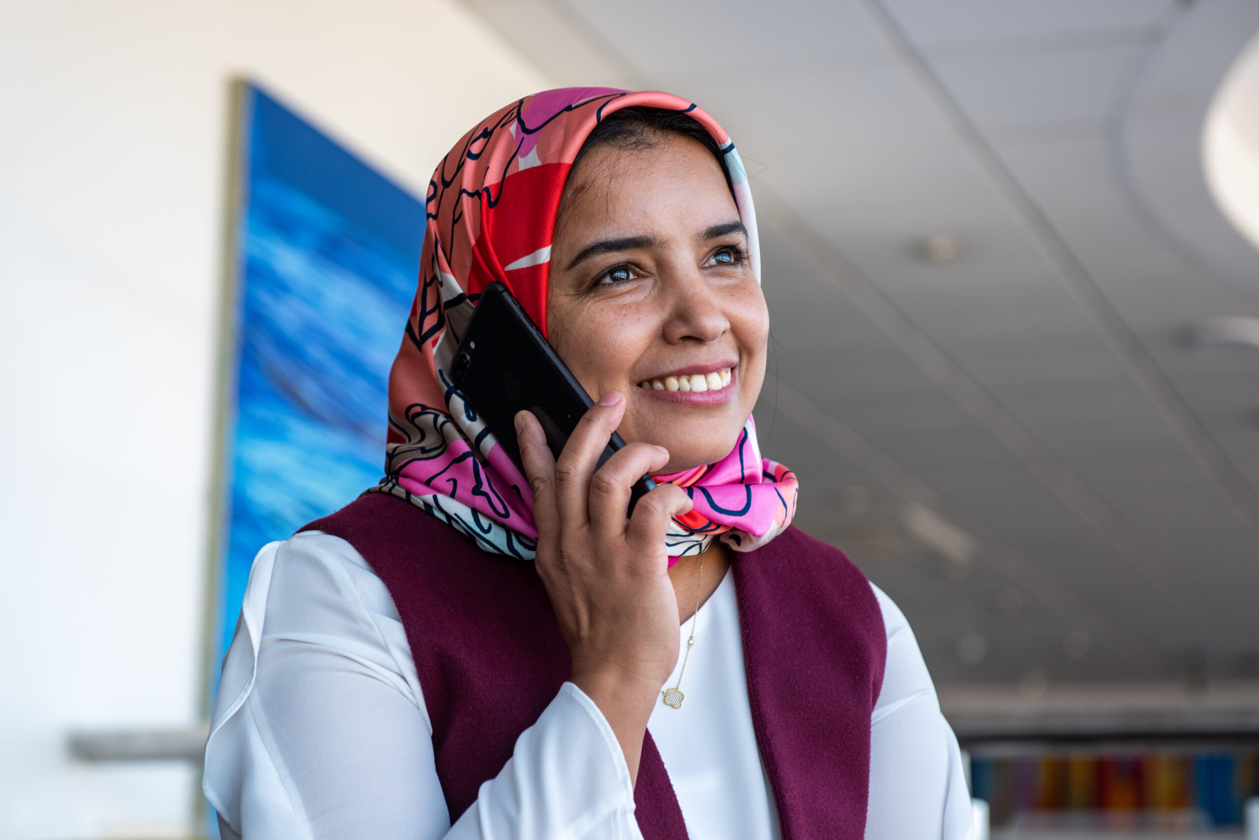 Lady using her mobile phone to speak to someone smiling