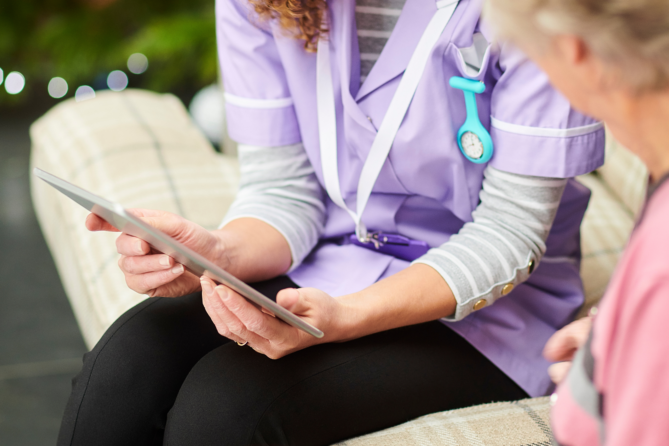 Care worker demonstrating how to use a tablet