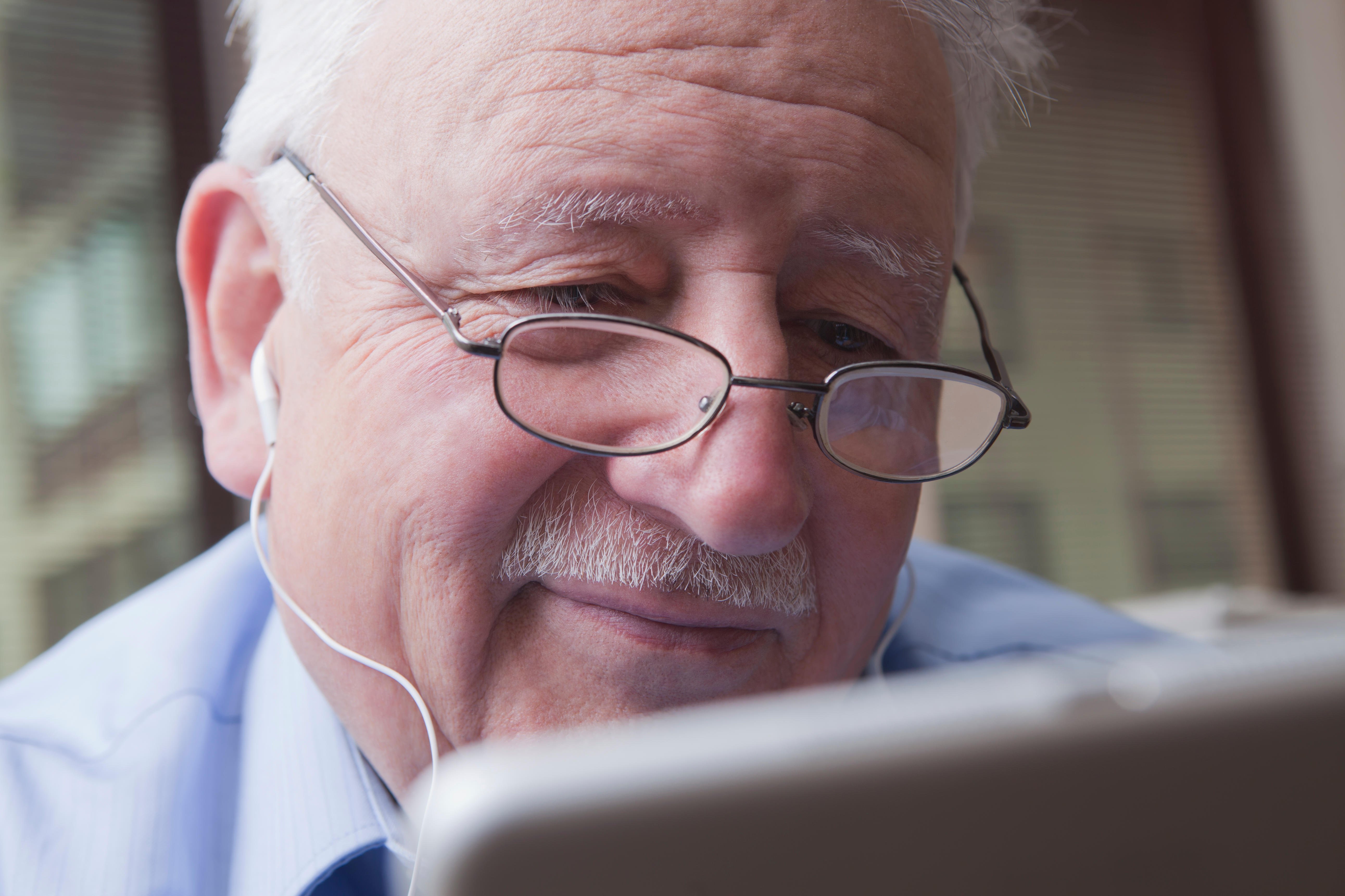 Man in hospital bed using digital device