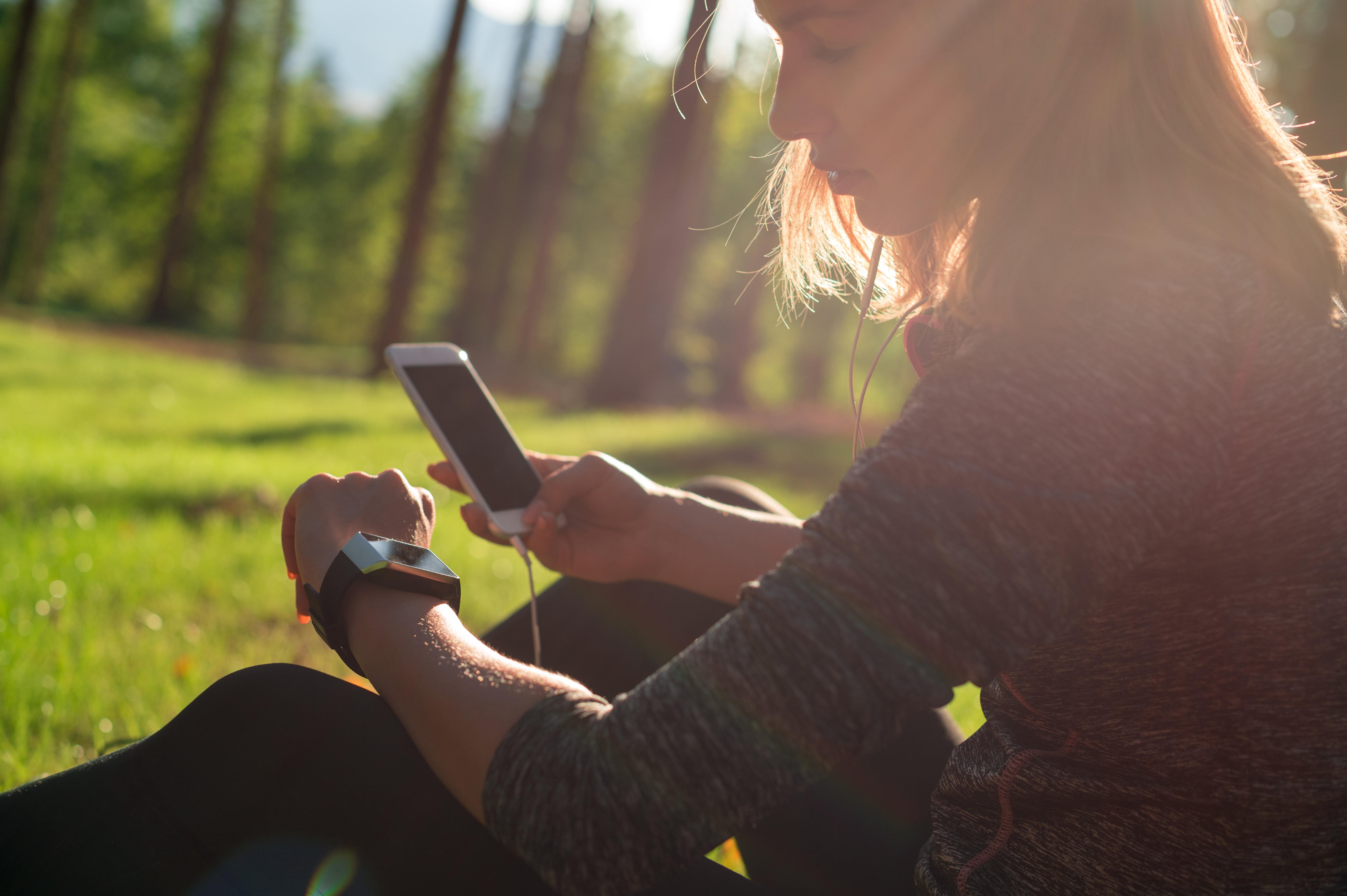 MBBHHJ Female athlete using fitness app on her smart watch to monitor workout performance.