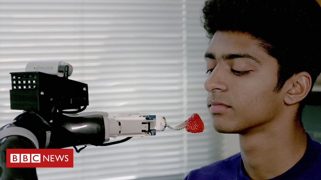 Robotic arm feeding a man