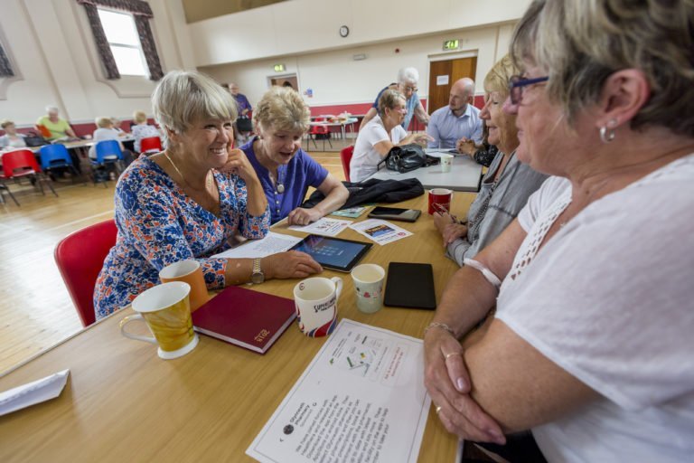 Senior ladies chatting over content display on an iPad