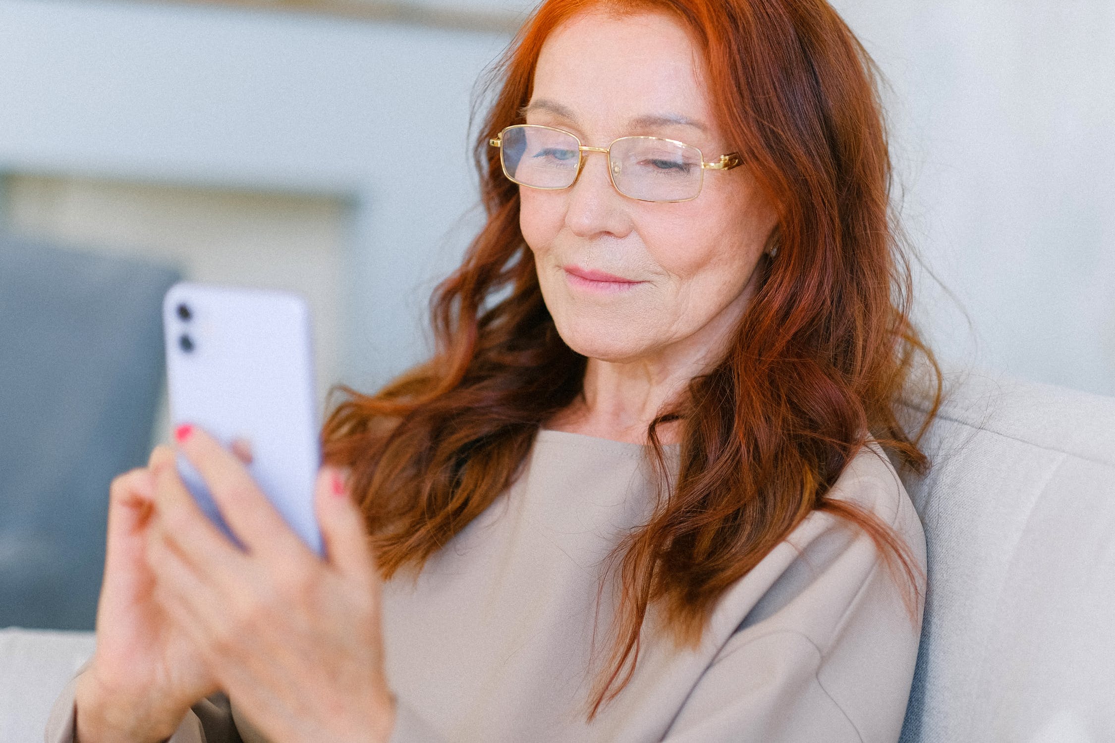 Older lady with red hair using smart phone