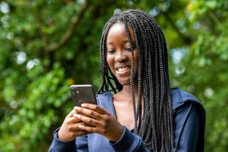 Teenage girl smiling into smartphone